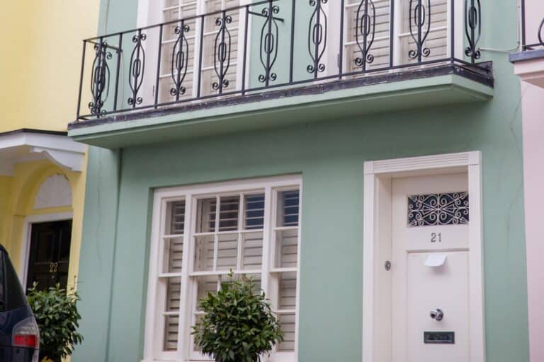 A light green British house with balcony