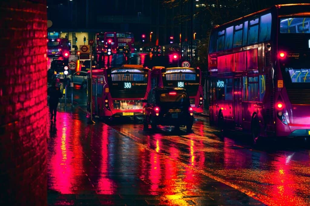 Buses and taxis stuck in heavy traffic at Lewisham station on a rainy night