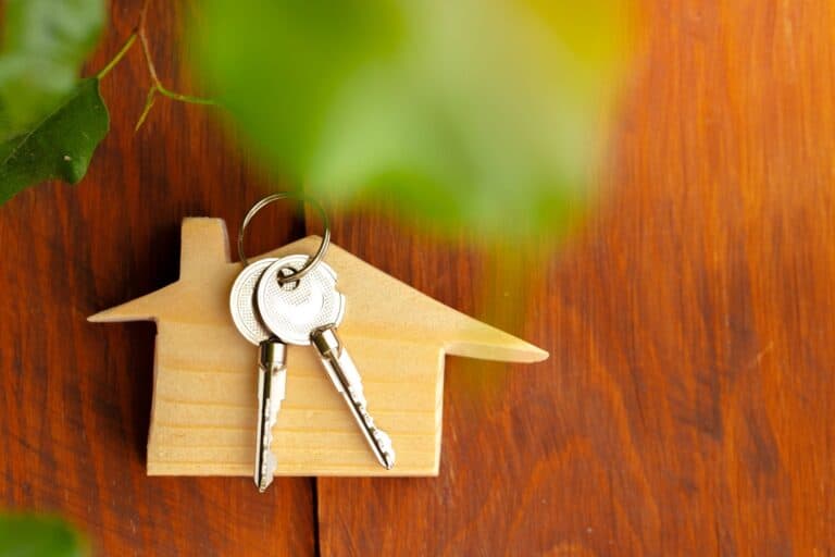 A wooden house model with keys in the concept of relocating