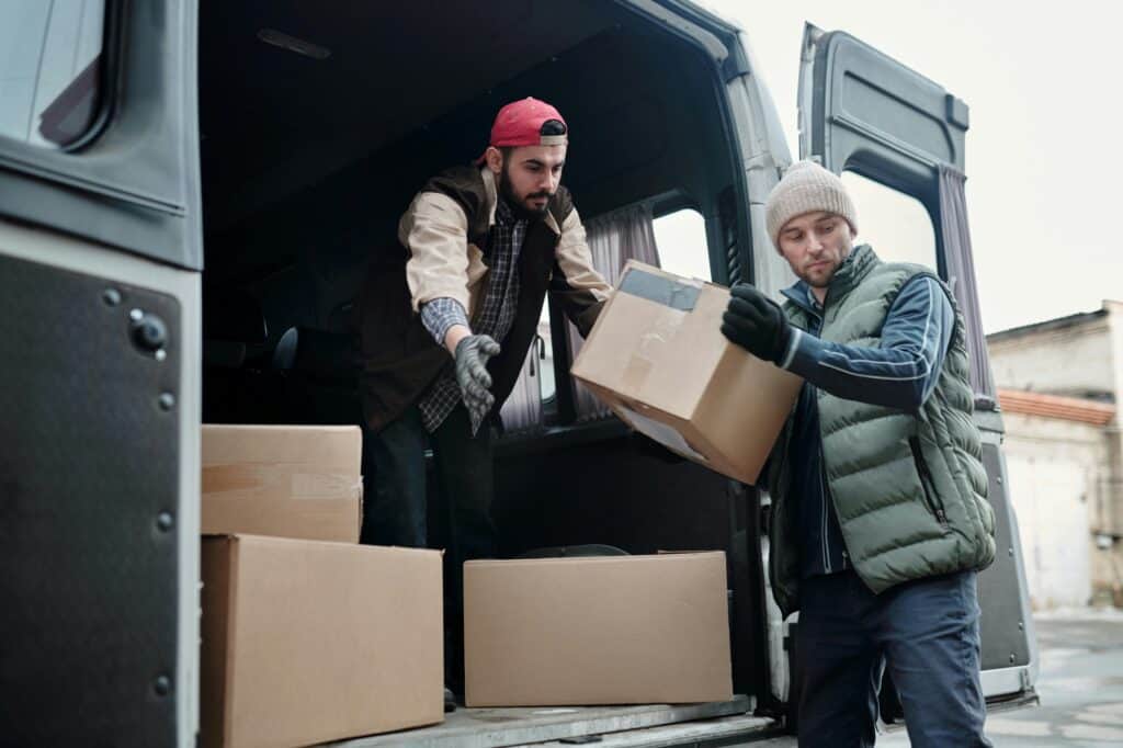 Professional movers taking out boxes from the van in the concept of a good man and van in Lewisham.