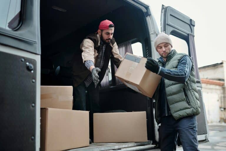 Professional movers taking out boxes from the van in the concept of a good man and van in Lewisham.